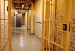 A prison corridor with open cell door and open prison gate